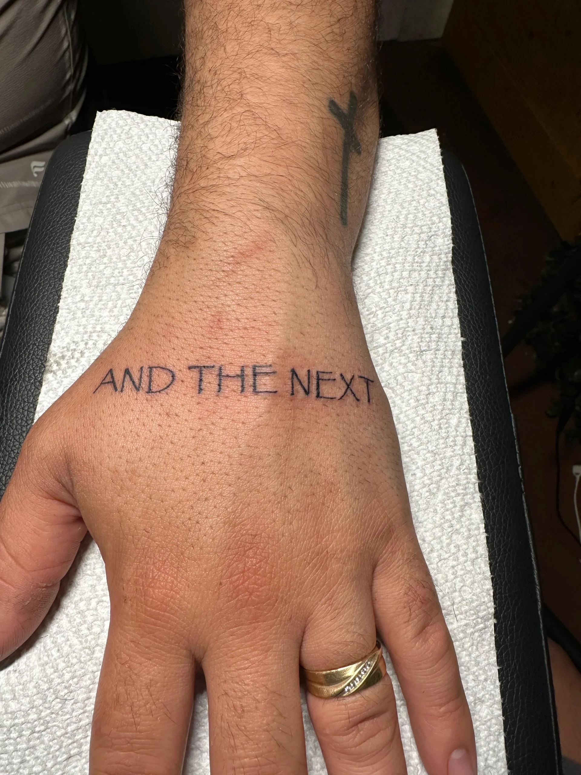 Hand lettering tattoo AND THE NEXT minimalist script Boca Raton tattoo artist