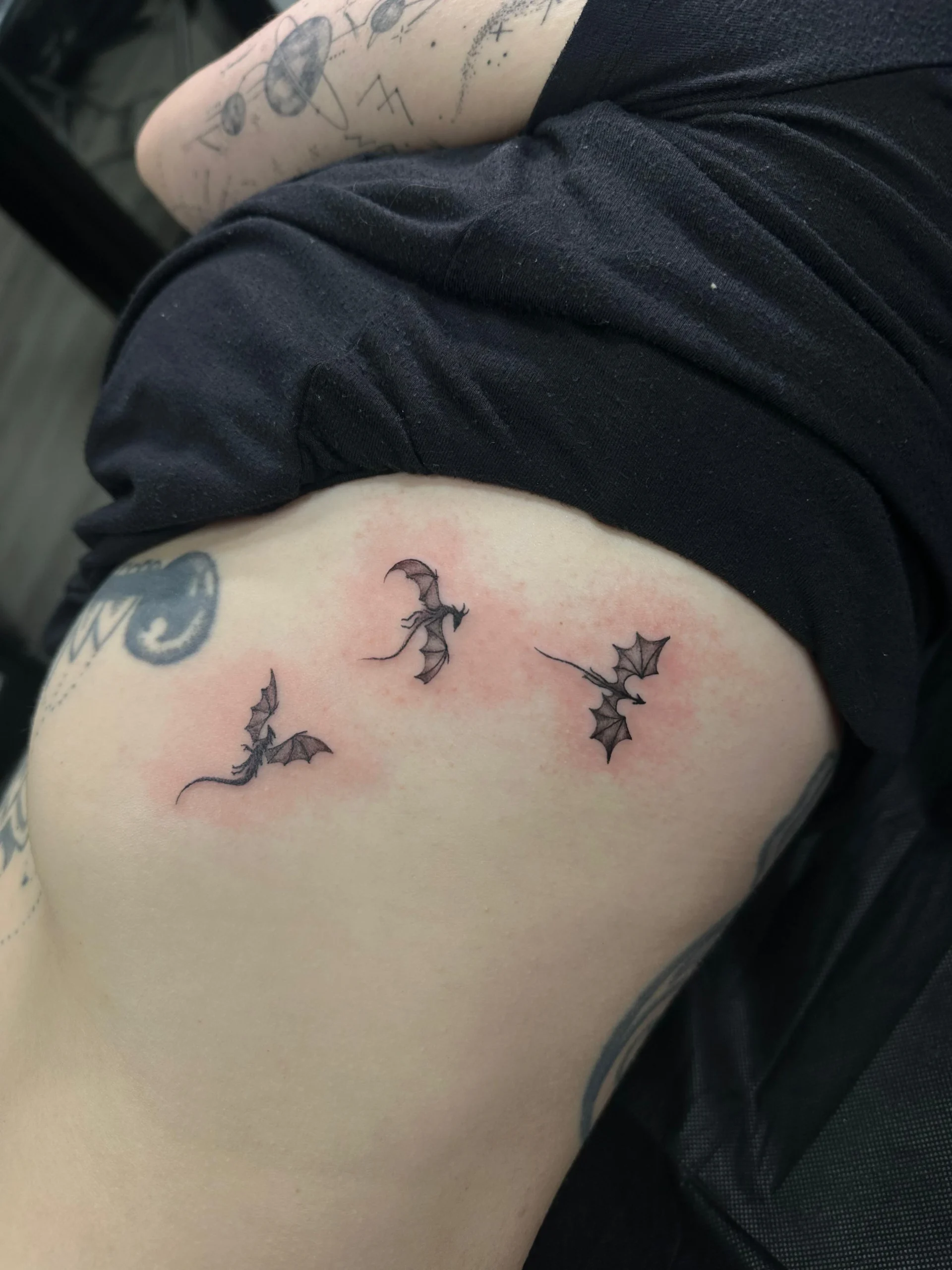 Small flying dragons rib tattoo fine line mythical creatures Boca Raton artist