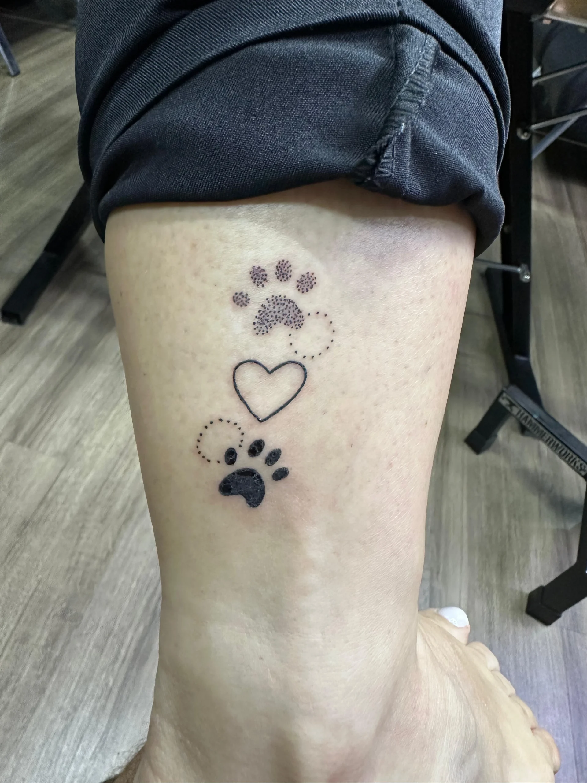 Minimalist dog paw print and heart tattoo dotwork style ankle ink Boca Raton