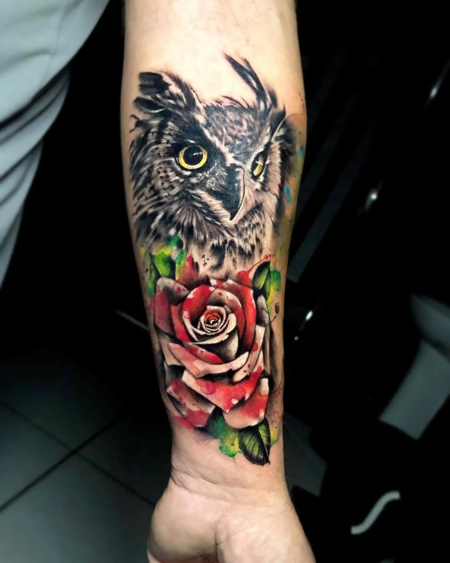 Detailed realistic owl head tattoo above a red rose on the forearm, nature and wildlife ink by a specialist in Boca Raton, Florida.