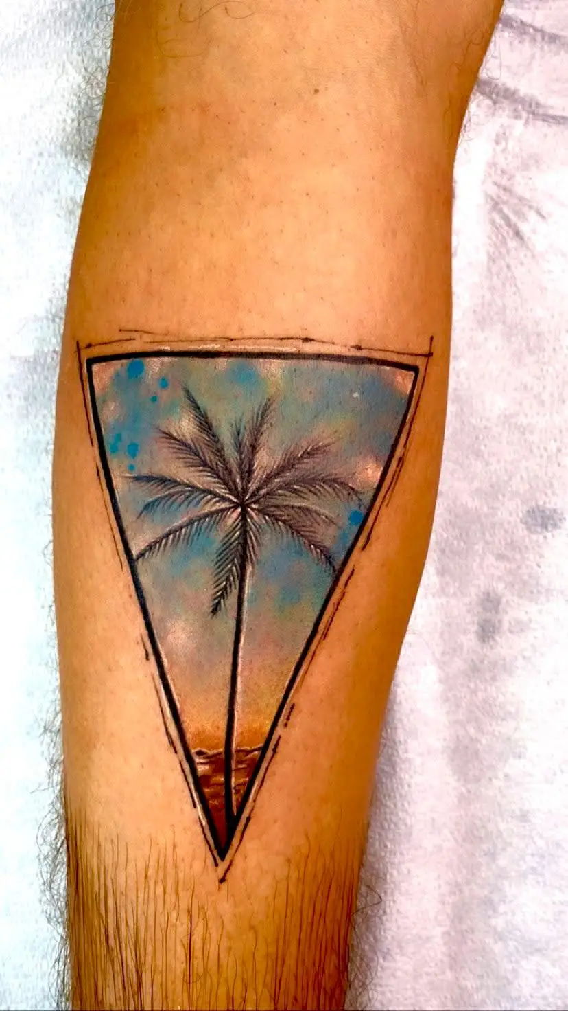 Tropical palm tree tattoo inside a geometric triangle frame with a blue sky, representing the Florida lifestyle, inked in Boca Raton.