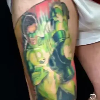 Tattoo of DC Comics superhero Green Lantern in green costume and mask, holding a glowing lantern, with vivid green and yellow colors on a persons upper arm. in Boca Raton, Florida
