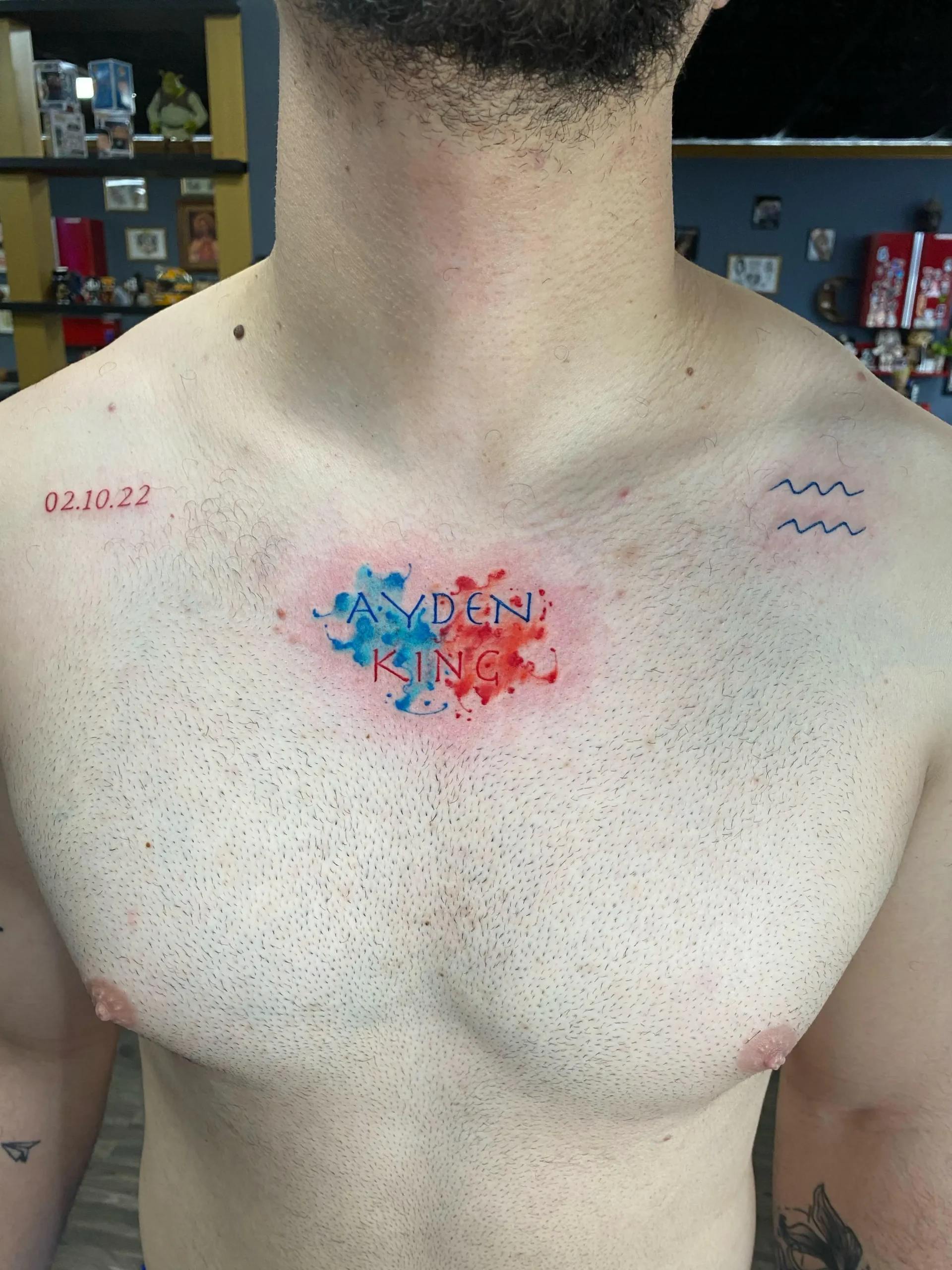 Chest lettering tattoo with blue and red watercolor splash memorial name ink Boca Raton