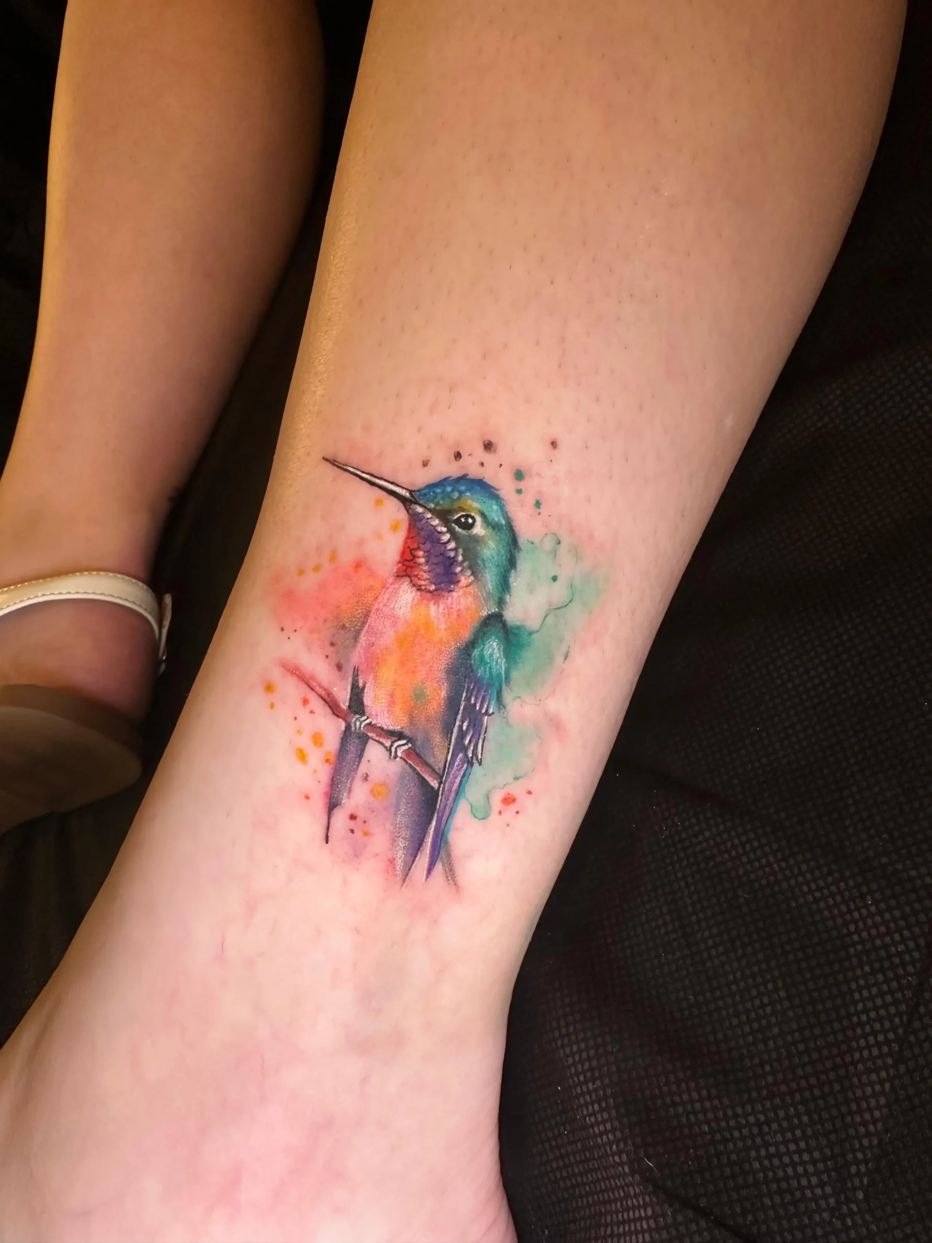 Small watercolor hummingbird tattoo on ankle colorful bird ink best tattoo shop Boca Raton
