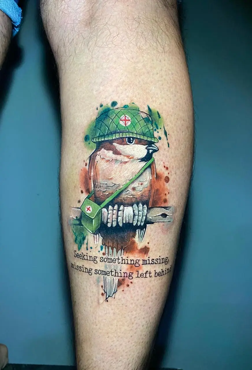 Watercolor sparrow tattoo wearing a soldier helmet with a medic cross and a meaningful quote, unique custom ink in Boca Raton, Florida.