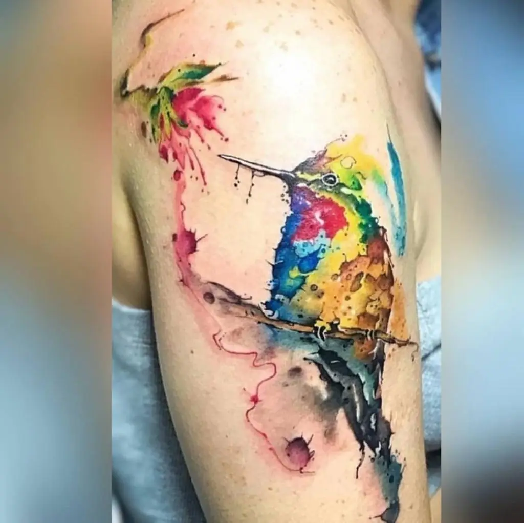 Watercolor hummingbird and red rose tattoo on the shoulder, delicate and vibrant floral bird ink by a specialist in Boca Raton, Florida.