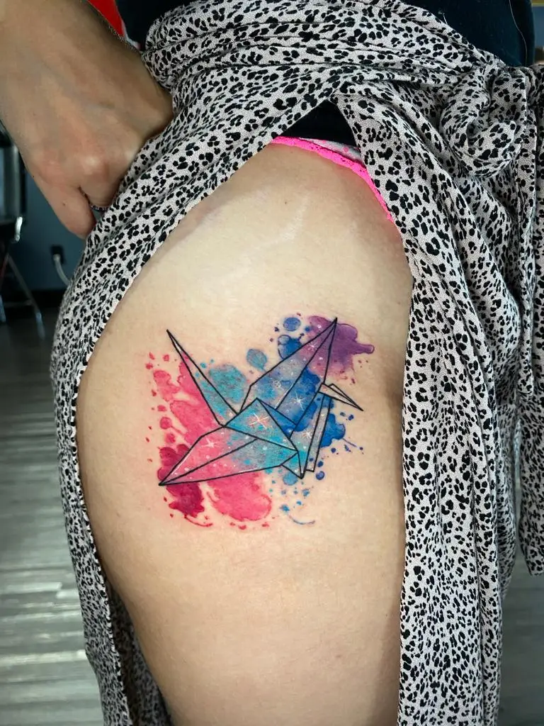 Geometric origami crane tattoo filled with galaxy watercolor effects on the hip, artistic Japanese bird ink in Boca Raton, Florida.